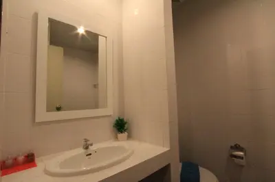 a white bathroom with a sink and a mirror at Sleep Easy in Kata Beach
