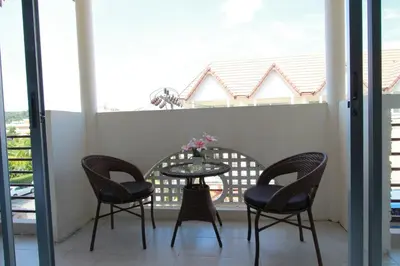a table and four chairs on a balcony at Sleep Easy in Kata Beach