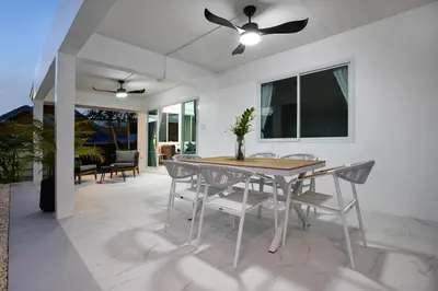 a dining room table with chairs and a ceiling fan at Private Pool Villa Rawai Beach in Rawai Beach