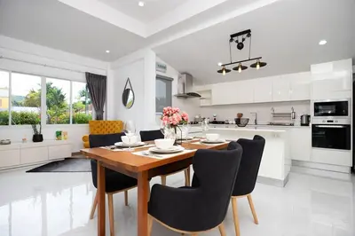 a kitchen and dining room with a wooden table and chairs at Private Pool Villa Rawai Beach in Rawai Beach