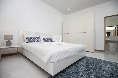 a white bedroom with a large bed and a mirror at Private Pool Villa Rawai Beach in Rawai Beach