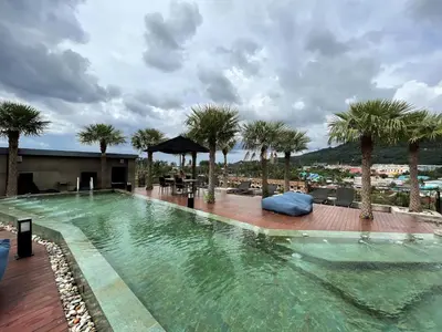 a large swimming pool with palm trees on a resort at Luxury private apartment Citygate by Lofty in Kamala Beach