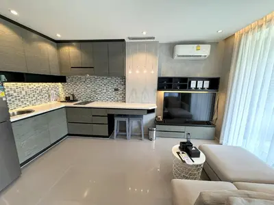 a kitchen and living room with a couch and a table at Luxury private apartment Citygate by Lofty in Kamala Beach
