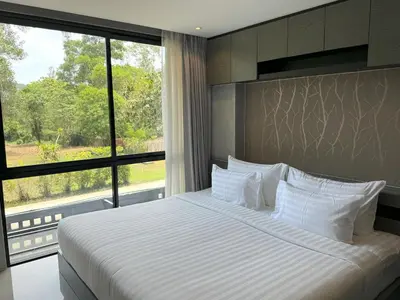 a bedroom with a large bed with a large window at Luxury private apartment Citygate by Lofty in Kamala Beach