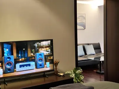 a living room with blue speakers and a mirror at Rawai beachfront - One bedroom on 3 floor at Title in Rawai Beach