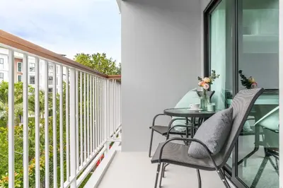a balcony with a table and chairs on it at Title V Pool View 3fl Gym Hammam Rawai in Rawai Beach
