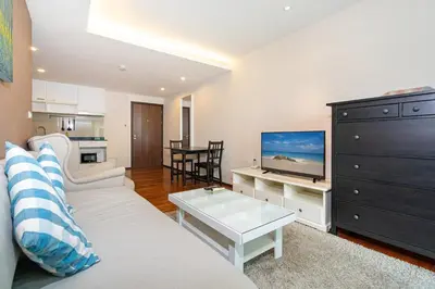 a living room with a couch and a flat screen tv at New Apartment TTL B209 in New Rawai Beach Residence with Tropical Pools in Rawai Beach