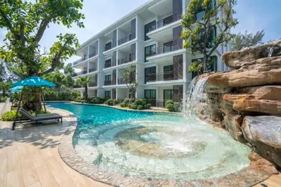 a swimming pool with a waterfall in front of a building at New Apartment TTL B209 in New Rawai Beach Residence with Tropical Pools in Rawai Beach