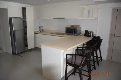 a kitchen with a counter with two chairs and a refrigerator at KALIM RESIDENCE unit 132 VUE MER in Patong Beach
