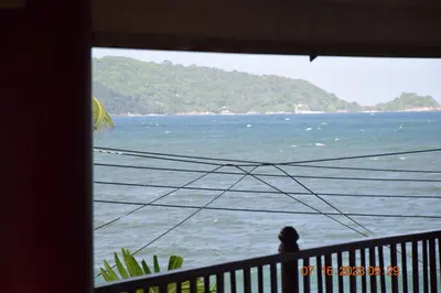 a person sitting on a balcony looking at the water at KALIM RESIDENCE unit 132 VUE MER in Patong Beach