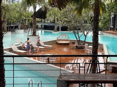 a swimming pool with two girls playing in the water at Kamala Beach D76 Exclusive Junior Suite in Kamala Beach
