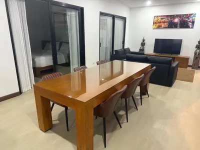 a living room with a wooden table and chairs at Beautiful private 4 bedroom villa with pool and gym in Rawai Beach