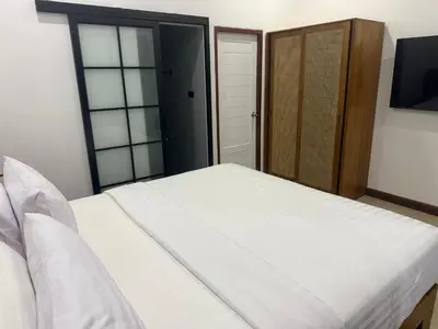 a bedroom with a white bed and a sliding door at Beautiful private 4 bedroom villa with pool and gym in Rawai Beach