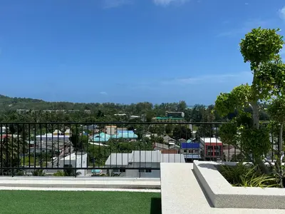 a view of a city from the balcony of a building at Great Hill Cozy Stay Pool Gym Naiyang in Phuket Town