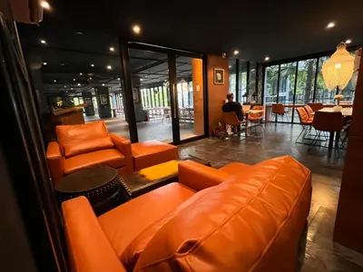 a living room with orange leather furniture and a table at Kamala Beach P67 Exclusive Junior Suite in Kamala Beach