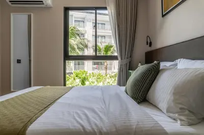a bedroom with a large bed with a window at Title V Sunny Holiday Pool View Gym Hammam in Rawai Beach