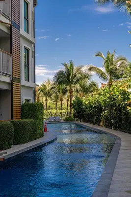 a swimming pool in the middle of a building with palm trees at Title V Sunny Holiday Pool View Gym Hammam in Rawai Beach
