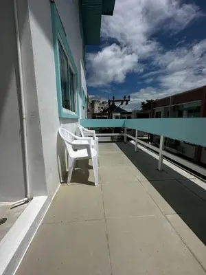 a pair of white chairs sitting on the side of a building at Abby's House Hotel in Patong Beach