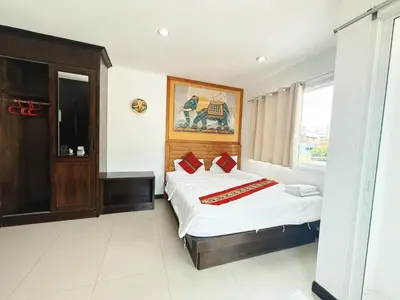 a bedroom with a bed with white sheets and red pillows at Abby's House Hotel in Patong Beach