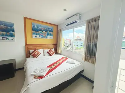 a hotel room with a bed with a window at Abby's House Hotel in Patong Beach