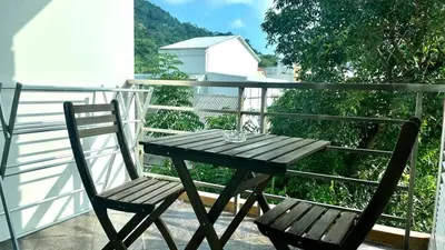 a wooden table and two chairs on a balcony at Haven Lagoon Condominium in Patong Beach