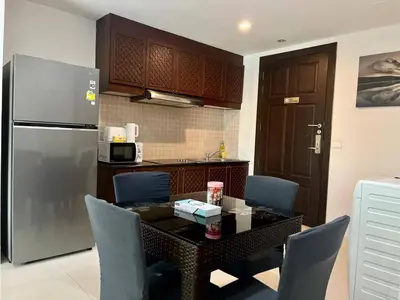 a kitchen with a table with chairs and a refrigerator at Haven Lagoon Condominium in Patong Beach