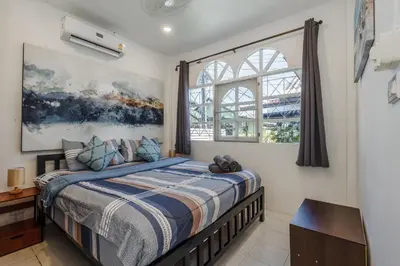 a bedroom with a bed and a window at Karon Beach Holiday Home 1 in Karon Beach