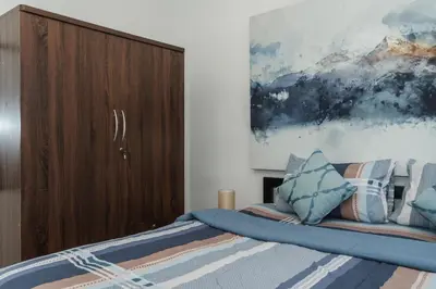 a bedroom with a bed and a painting on the wall at Karon Beach Holiday Home 1 in Karon Beach