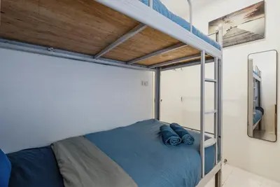 a bedroom with a bunk bed with blue pillows on it at Karon Beach Holiday Home 1 in Karon Beach