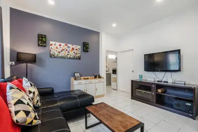 a living room with a couch and a flat screen tv at Karon Beach Holiday Home 1 in Karon Beach