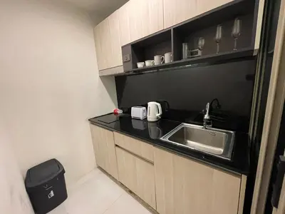 a small kitchen with a sink and a trash can at Oceana Resort Kamala Ocean View 5th floor in Kamala Beach