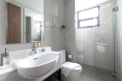 a bathroom with a sink and a toilet and a mirror at Modern villa with pool close to the beach - LP #97 in Phuket Town