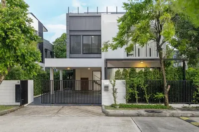 a white house with a black fence and trees at Modern villa with pool close to the beach - LP #97 in Phuket Town