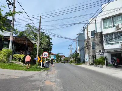 an empty street with a speed limit sign on the corner at Nai Harn beach - Studio room on 2 floor at ReLife The Windy in Rawai Beach