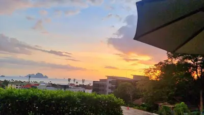 a sunset over a city with buildings and the ocean at Silk Ao Nang Condominium in Ao Nang Beach