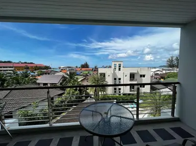 a balcony with a table and a view of a city at Luxurious 3BR Penthouse Jacuzzi Seaview in Kamala Beach
