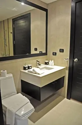 a bathroom with a sink and a toilet and a mirror at Luxurious 3BR Penthouse Jacuzzi Seaview in Kamala Beach