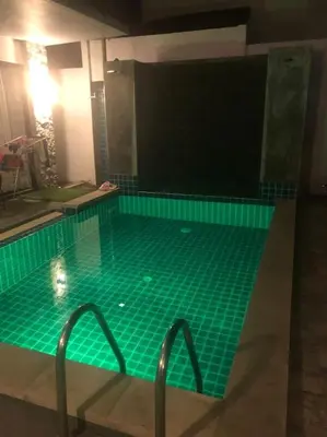 a swimming pool with green tiles in a room at Exquisite 3BR Private Pool Villa: Prime Location in Kamala Beach