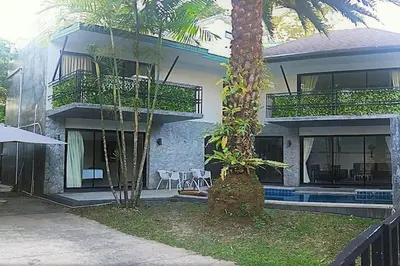 a house with a palm tree in front of it at Exquisite 3BR Private Pool Villa: Prime Location in Kamala Beach