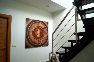 a painting hanging on a wall next to a staircase at Stunning 4-BR House with Inviting Swimming Pool in Kamala Beach