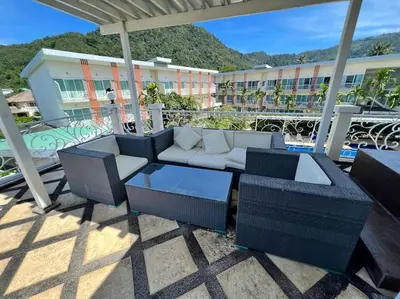 a patio with a couch and tables and a building at Stunning 4-BR House with Inviting Swimming Pool in Kamala Beach