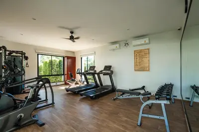 a gym with a bunch of treadmills and machines at The Title V Rawai by Beringela in Phuket Town