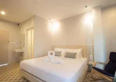 a bedroom with a bed with two swans on it at Nature Pine Phuket เนเชอร์ไพน์ภูเก็ต in Rawai Beach