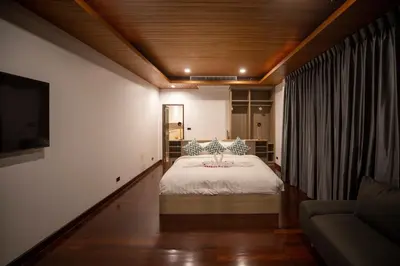 a bedroom with a bed and a couch at Phuket Superior Sunrise Sea View Private Pool Villa in Kata Beach