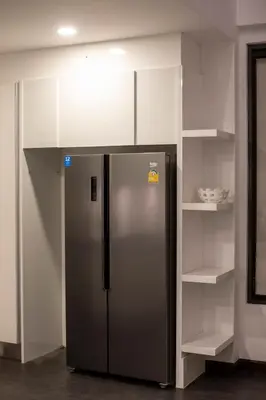 a stainless steel refrigerator in a kitchen with shelves at Phuket Superior Sunrise Sea View Private Pool Villa in Kata Beach