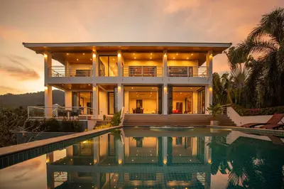a house with a swimming pool in front of it at Phuket Superior Sunrise Sea View Private Pool Villa in Kata Beach
