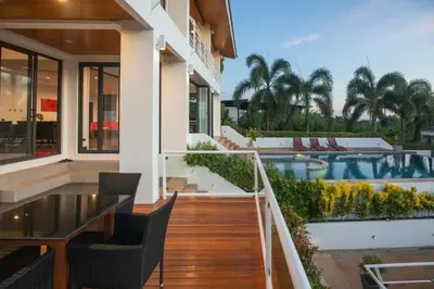 a house with a balcony with a swimming pool at Phuket Superior Sunrise Sea View Private Pool Villa in Kata Beach
