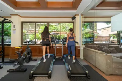 two women standing on treadmills in a gym at Patong Central Residence & Apartment in Patong Beach