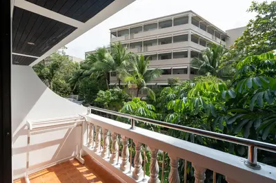 a balcony with trees and a building in the background at Patong Central Residence & Apartment in Patong Beach