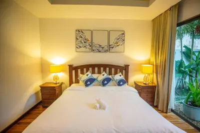 a bedroom with a bed with two lamps and a window at Phuket Boutique Pool Villa-79 in Rawai Beach